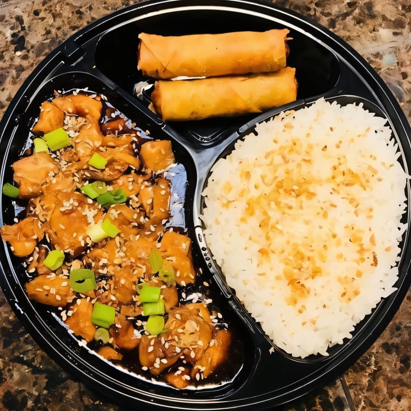 Filipino takeout meal with chicken adobo, white rice, and two crispy lumpia spring rolls.